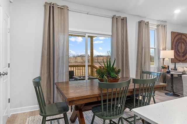 dining space featuring recessed lighting, baseboards, plenty of natural light, and light wood finished floors