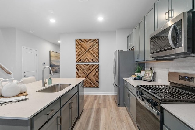 kitchen with stainless steel appliances, gray cabinets, recessed lighting, and a sink