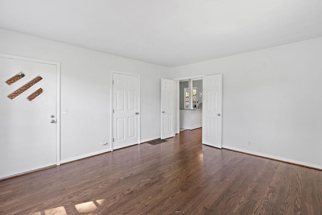 interior space featuring baseboards and wood finished floors