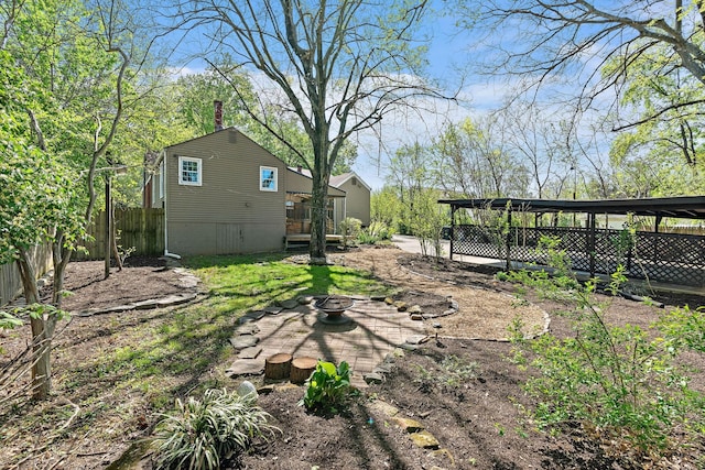 view of yard featuring fence and an outdoor fire pit