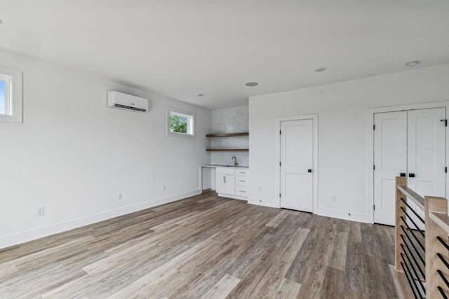 1303 Katie Ave Unit B, Nashville, TN 37207 - unfurnished living room featuring a sink, baseboards, an AC wall unit, and light wood finished floors