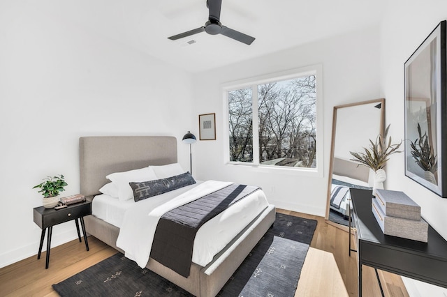 bedroom featuring a ceiling fan, baseboards, and wood finished floors
