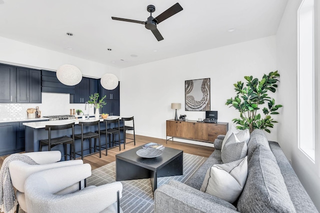 living area featuring a ceiling fan and light wood-style flooring