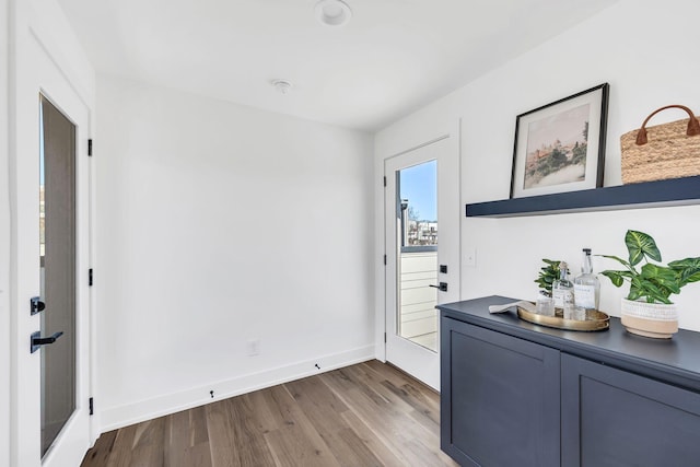 doorway to outside with baseboards and wood finished floors