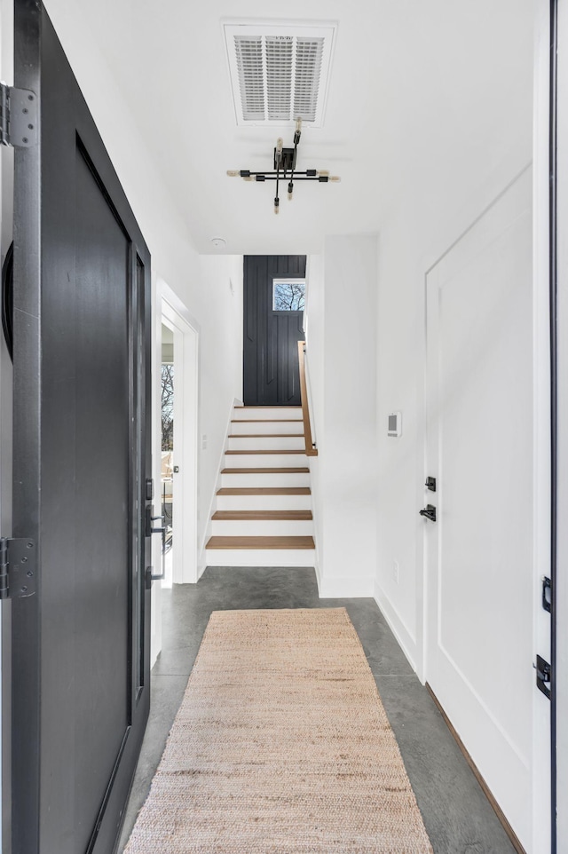 interior space with baseboards, visible vents, stairway, and finished concrete flooring