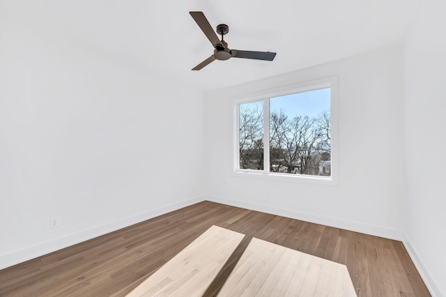 empty room featuring baseboards, ceiling fan, and wood finished floors