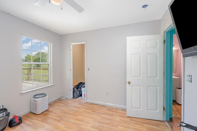 unfurnished bedroom featuring baseboards, ceiling fan, and light wood-style floors