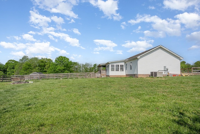 view of yard featuring central air condition unit and fence