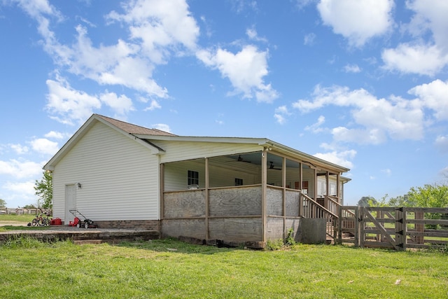 view of side of home featuring fence and a yard
