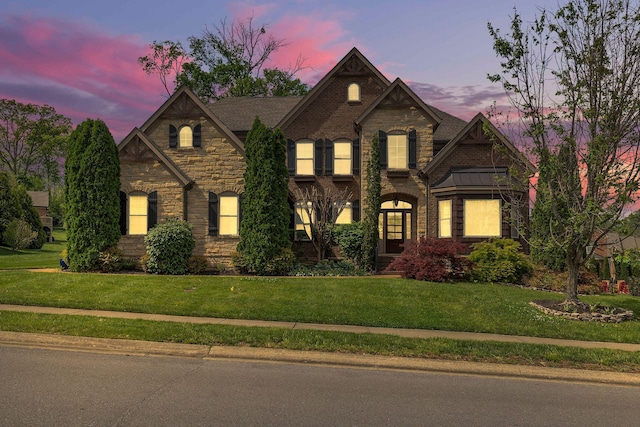 view of front of property with a yard and stone siding