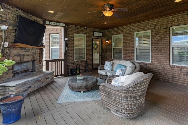 wooden terrace featuring a ceiling fan and an outdoor living space with a fireplace