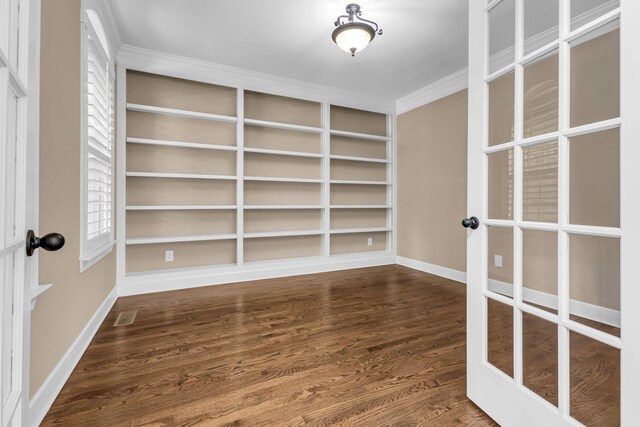 spare room with visible vents, crown molding, built in features, baseboards, and dark wood-type flooring