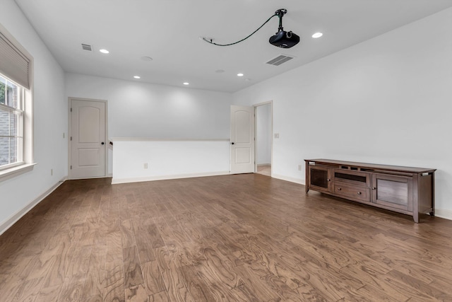 empty room with baseboards, recessed lighting, wood finished floors, and visible vents
