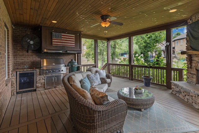 wooden deck with exterior kitchen, beverage cooler, ceiling fan, grilling area, and an outdoor living space