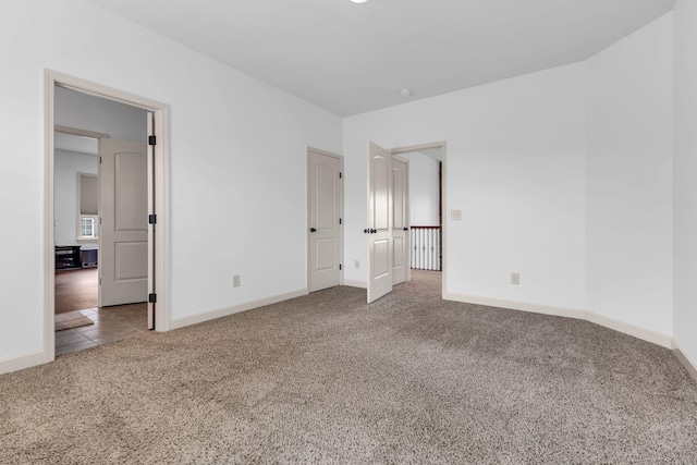 unfurnished bedroom featuring baseboards and carpet