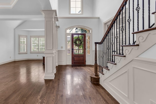 foyer entrance featuring dark wood-style floors, a wealth of natural light, and stairway