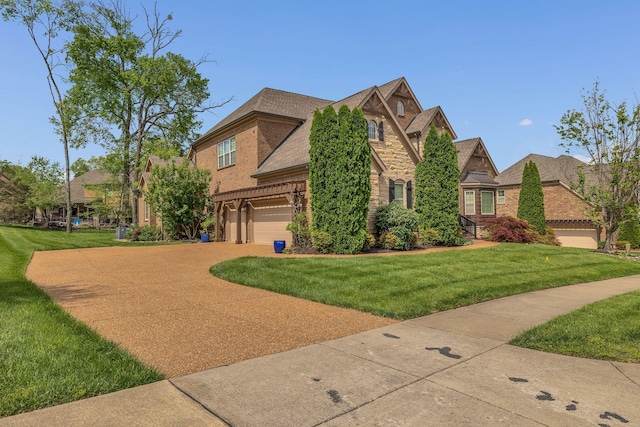 view of front of home featuring an attached garage, brick siding, a front yard, and concrete driveway