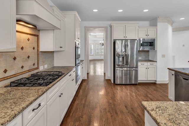 kitchen featuring backsplash, dark wood-style flooring, light stone countertops, white cabinets, and stainless steel appliances