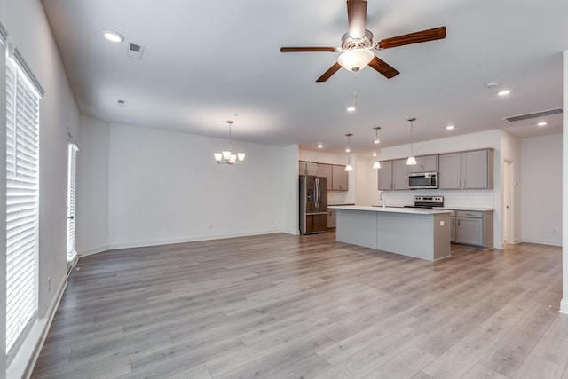 kitchen with appliances with stainless steel finishes, gray cabinets, recessed lighting, and open floor plan