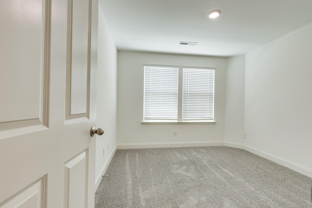 carpeted spare room with baseboards and visible vents