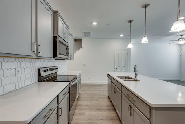 kitchen with visible vents, a sink, gray cabinetry, and stainless steel appliances