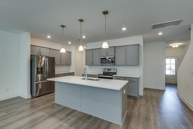 kitchen with gray cabinetry, appliances with stainless steel finishes, a sink, and visible vents