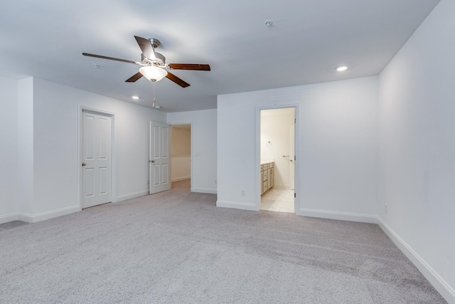 unfurnished bedroom featuring ceiling fan, ensuite bath, light colored carpet, baseboards, and recessed lighting