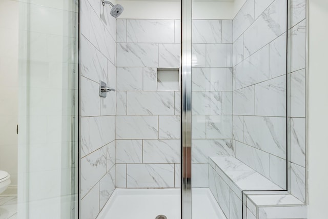 bathroom featuring toilet and a shower stall