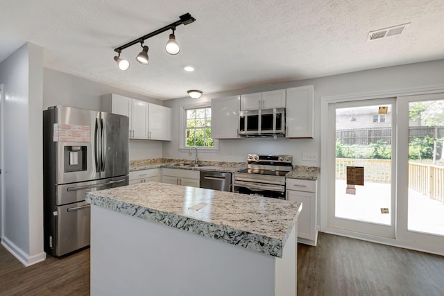 217 Sterry Ct, Antioch, TN 37013 - kitchen featuring white cabinets, appliances with stainless steel finishes, a sink, dark wood finished floors, and visible vents