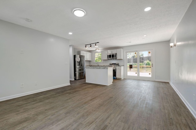 217 Sterry Ct, Antioch, TN 37013 - kitchen with dark wood-style flooring, a kitchen island, open floor plan, white cabinets, and appliances with stainless steel finishes
