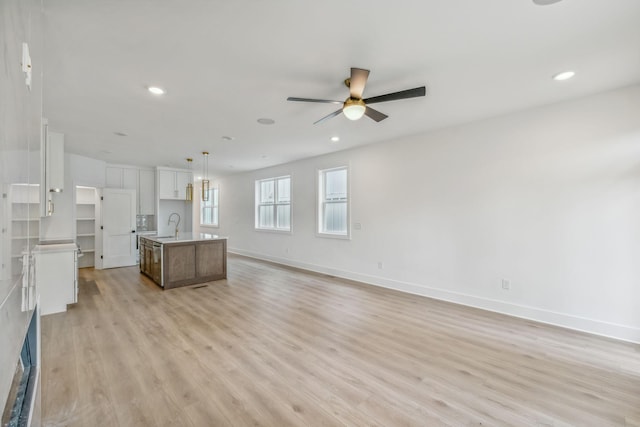 unfurnished living room with baseboards, a ceiling fan, light wood-style flooring, and recessed lighting