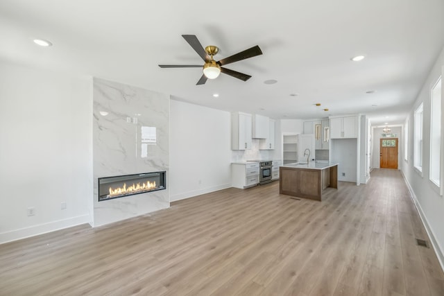 unfurnished living room featuring light wood-style floors, a fireplace, and recessed lighting