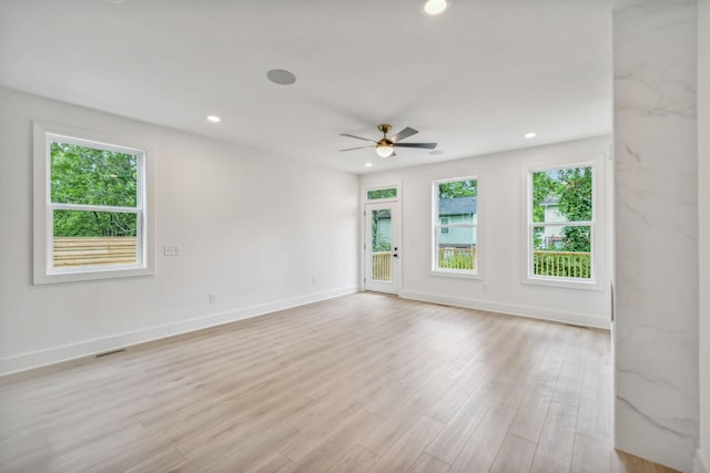 unfurnished room with plenty of natural light, light wood finished floors, ceiling fan, and visible vents