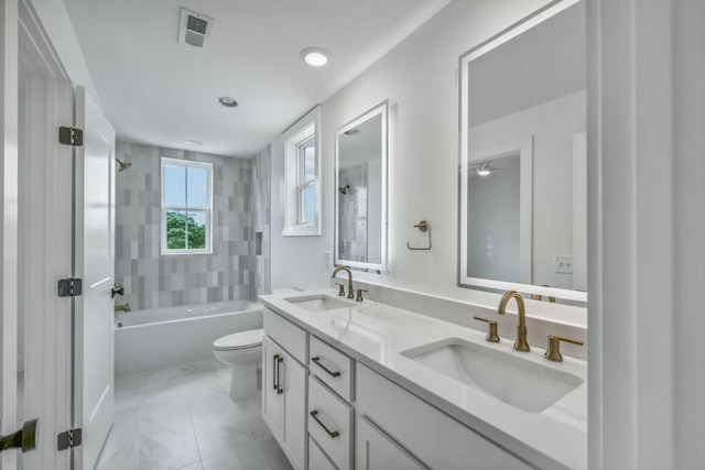 bathroom featuring a sink, bathtub / shower combination, toilet, and visible vents