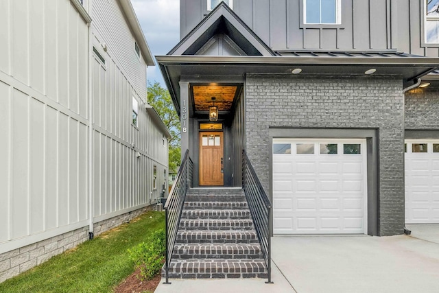 property entrance featuring an attached garage, board and batten siding, and concrete driveway