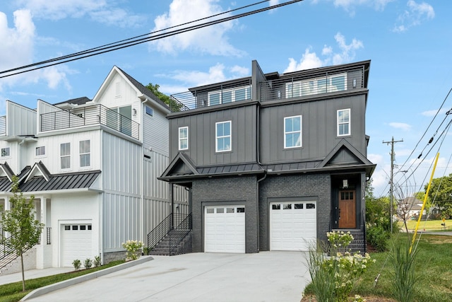 view of property featuring board and batten siding, a standing seam roof, driveway, a balcony, and an attached garage