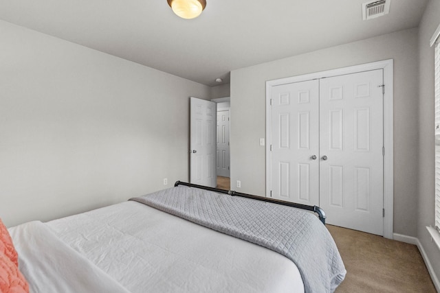 bedroom featuring light colored carpet, baseboards, visible vents, and a closet