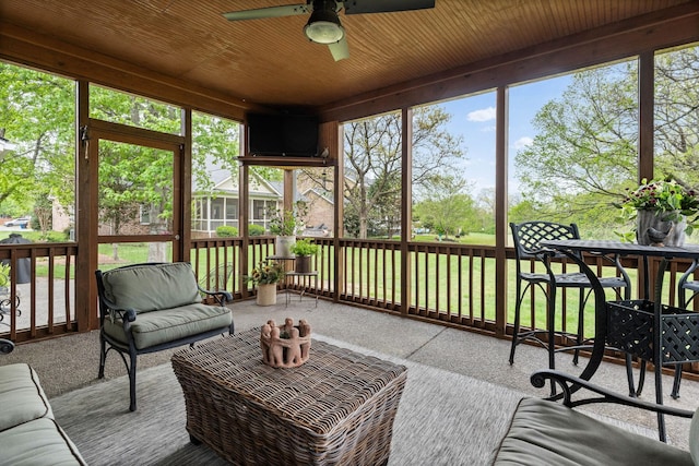 sunroom featuring a ceiling fan and plenty of natural light