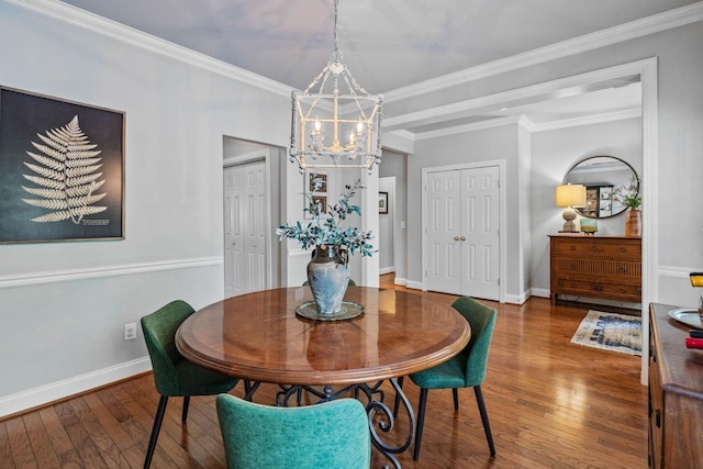 dining space featuring an inviting chandelier, ornamental molding, baseboards, and hardwood / wood-style floors