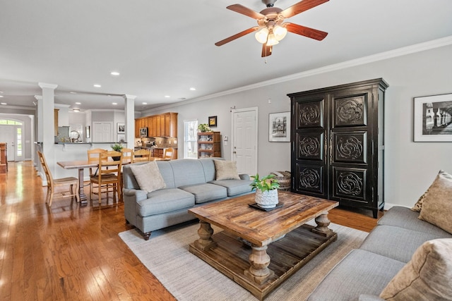 living room with crown molding, ceiling fan, ornate columns, recessed lighting, and light wood-style flooring