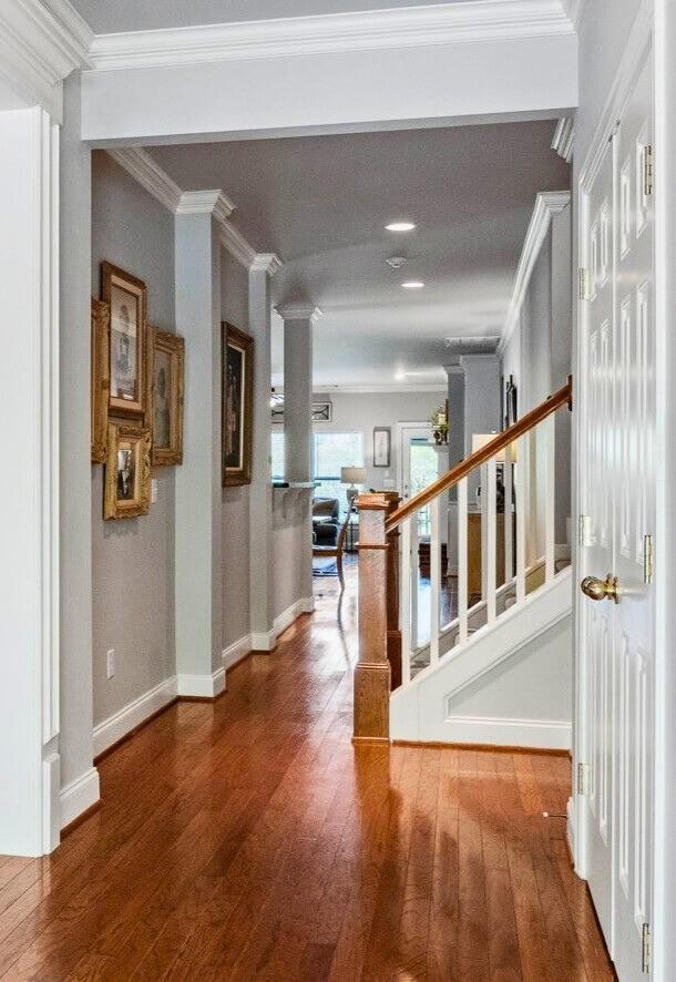hallway with stairway, baseboards, ornamental molding, and wood-type flooring