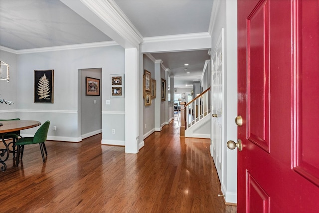 foyer entrance with crown molding, baseboards, wood finished floors, and stairway