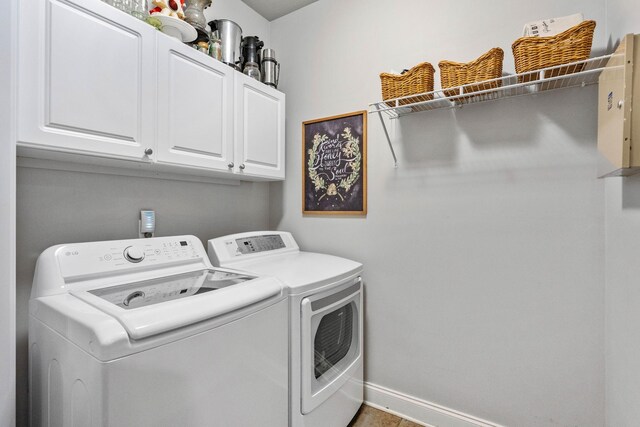 laundry room with cabinet space, baseboards, and washer and clothes dryer