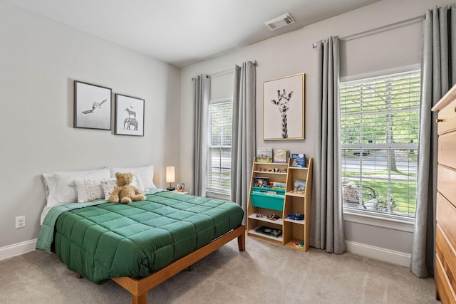 bedroom with baseboards, multiple windows, light carpet, and visible vents