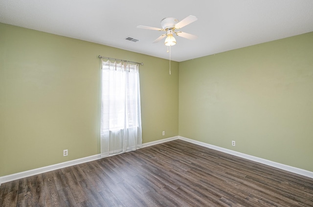 unfurnished room with baseboards, visible vents, a ceiling fan, and dark wood-type flooring