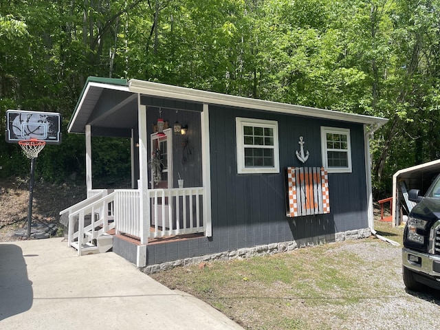 view of front of home with a porch and a view of trees