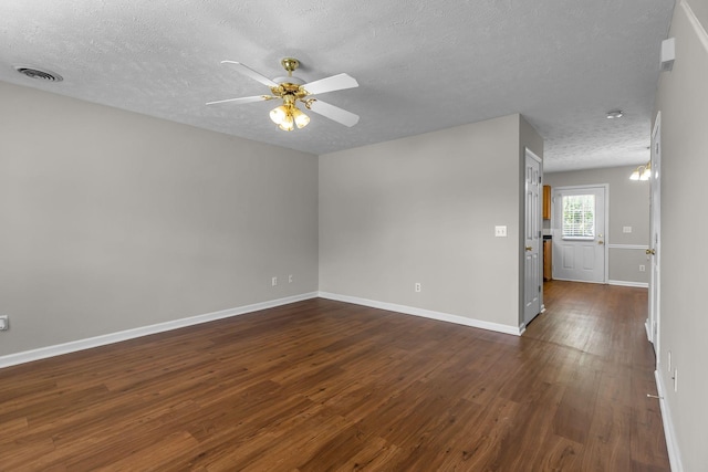 empty room featuring a ceiling fan, a textured ceiling, visible vents, baseboards, and dark wood-style floors