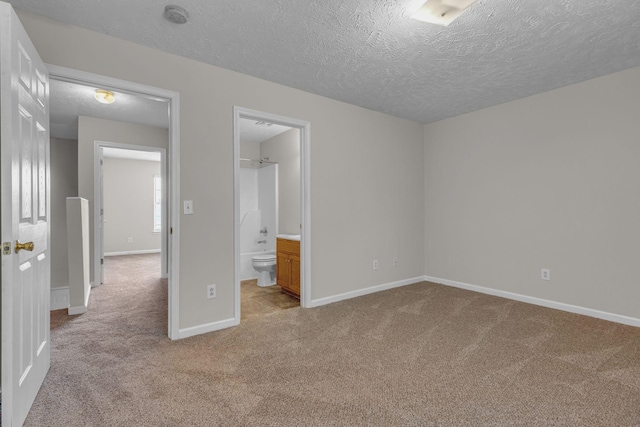 unfurnished bedroom with a textured ceiling, light colored carpet, and baseboards