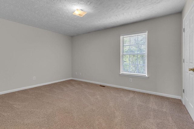 unfurnished room featuring carpet floors, a textured ceiling, and baseboards