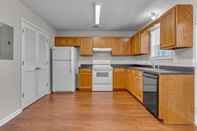 kitchen featuring electric panel, dark countertops, a sink, under cabinet range hood, and white appliances